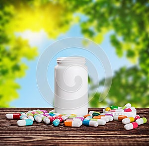 Pills of different colors and a bottle of medicine against