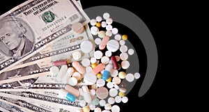 Pills on dollar money isolated on black background. Medicine expenses. High costs of medication concept