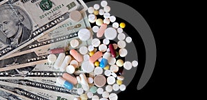 Pills on dollar money isolated on black background. Medicine expenses. High costs of medication concept