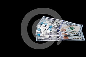 Pills on dollar money isolated on black background. Medicine expenses. High costs of medication concept. Place for text