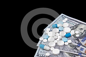 Pills on dollar money isolated on black background. Medicine expenses. High costs of medication concept. Place for text