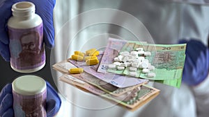 Pills dropped on hryvnias banknotes, expensive treatment, corruption in medicine