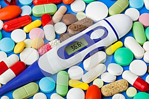 Pills and electronic thermometer 36.6 degrees - medical background