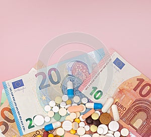 A pills and euro on a pink background with copy space. Soft focus. Concept of medicine, money and health