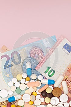 A pills and euro on a pink background with copy space. Soft focus. Concept of medicine, money and health