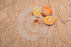 Pills and fruits. Mandarins and orange pills. Crumpled paper background. Citrus fruit.