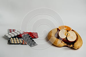 Pills and fruits on a white background