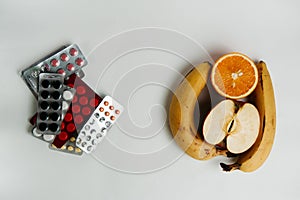 Pills and fruits on a white background