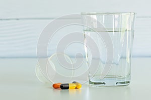 Pills and a glass of drinking water with pill cup