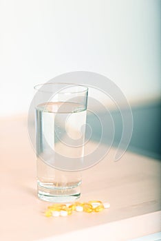 Pills and glass of water vertical