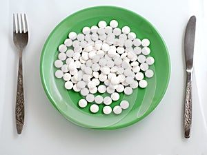 Pills on green plate