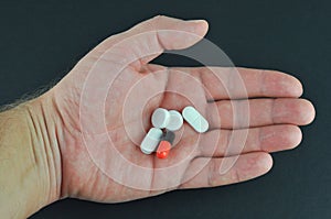 Pills and capsule in hand