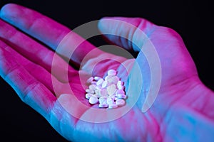 Pills in hand. Drug tablets in palm close-up