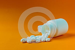 Pills that have fallen on an orange background