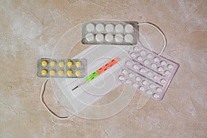 Pills, medical mask and thermometer