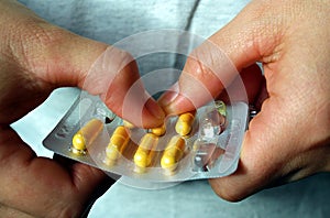 Pills medication with packaging on hand for oral administration