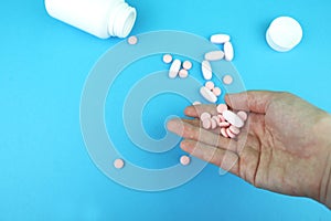 Pills and medicines in the hand on a blue background