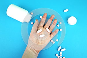 Pills and medicines in the hand on a blue background