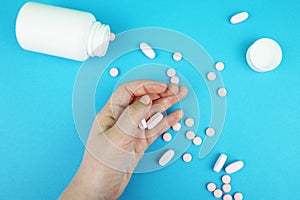 Pills and medicines in the hand on a blue background