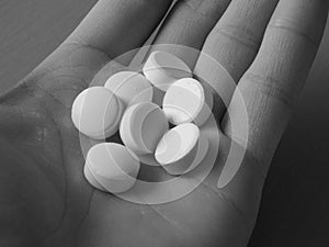 Pills on men palm in black and white colors