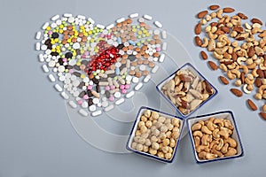 Pills and nuts different types in the shape of heart. Healthy  concept