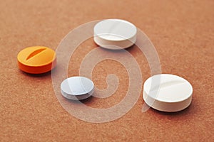 Pills over a brown background. Medicament treatment. Health care