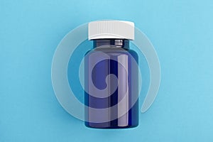 Pills package, Close up pill bottle on blue background. Medicine, medical insurance or pharmacy concept close up with copy space
