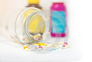 Pills and pill bottle on white background