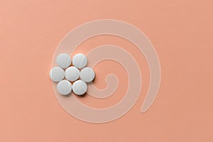 Pills on pink background, supplement concept. Copy space