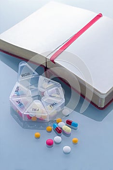 Pills planner with weekly medication capsules and note book