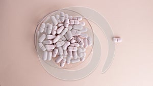 Pills on plate pink background and one on background. Creative concept for Valentine's Day or Pharmacy, Dietary