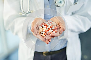 Pills for prevention and cure. Closeup shot of an unidentifiable doctor holding a variety of pills in her hands.