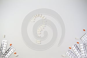 Pills in the shape of a question mark and tablets on white background. Medical, healthcare concept.