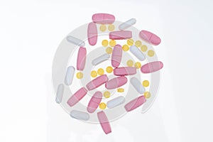 Pills spilling out of pill bottle. Assorted pharmaceutical medicine pills, tablets and capsules on white background. Antiretrovira