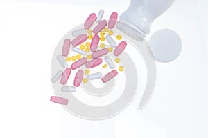 Pills spilling out of pill bottle. Assorted pharmaceutical medicine pills, tablets and capsules on white background. Antiretrovira