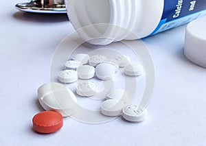 Pills spilling out of pill bottle and isolated on white background. Top view with copy space. Medicine concept