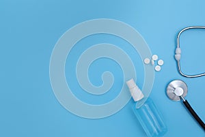 Pills spilling out of pill bottle syringe and thermometer on blue background. Virus protection concept. Flat lay, top view, copy