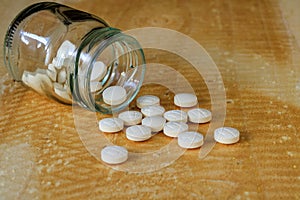 Pills spilling out of pill bottle on table