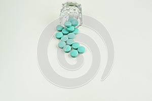 Pills spilling out of pill bottle on white background. copy space