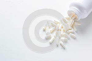 Pills spilling out of pill bottle on white background with copy space. medicine concept