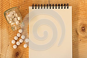 Pills spilling out of pill bottle on wooden table