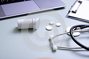 Pills, stethoscope with laptop and tablet at doctor's workplace. Variative focus