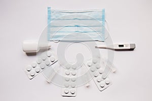 Pills stethoscope and protective mask on a white background