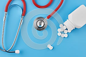 Pills tablets capsules closeup. On a blue background, a jar of medicine. On a blue background, a jar of medicine and a stethoscope