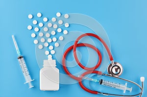 Pills tablets capsules closeup. On a blue background, a jar of medicine. On a blue background, a jar of medicine and a stethoscope