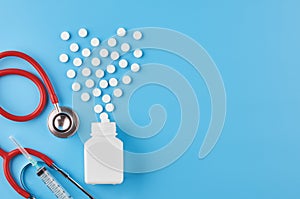 Pills tablets capsules closeup. On a blue background, a jar of medicine. On a blue background, a jar of medicine and a stethoscope