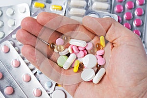 Pills, tablets, vitamins and drugs heap in mature hands