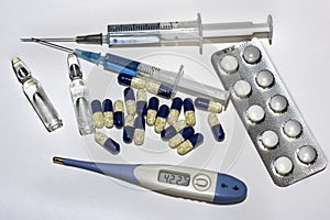 Blue syringes, blue thermometer, blue pills and ampules.