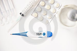 Pills, thermometer and syringes on white background. Coronavirus COVID-19 epidemic. Flat lay, top view, copy space