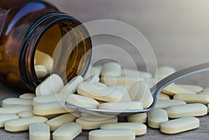 Pills or vitamin in Medicine bottles on the spoon background